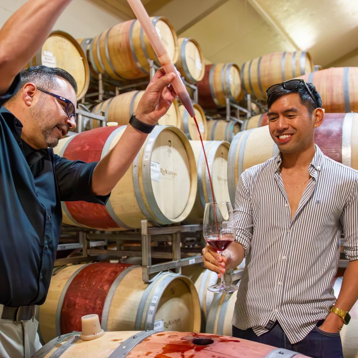 Wine pouring from barrel to glass during winery tour in Napa Valley